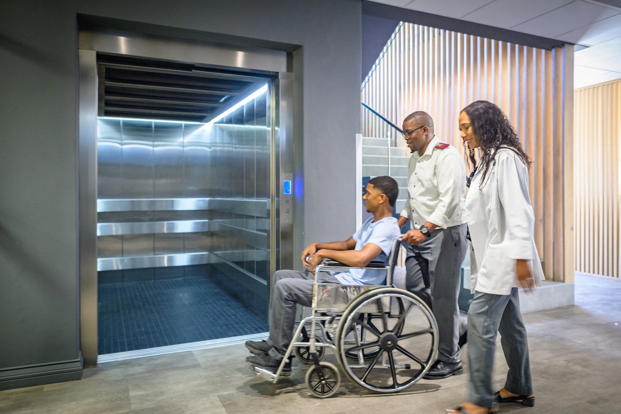 Male nurse and female doctor pushing male patient
